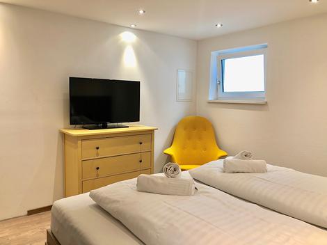 Schlafzimmer mit kleinem Fenster im Zwei-Zimmer-Apartment