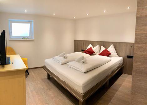 Schlafzimmer mit kleinem Fenster im Zwei-Zimmer-Apartment